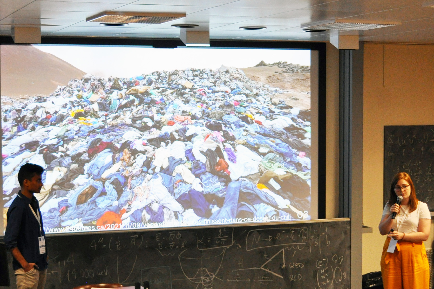 Two students presenting next to a screen